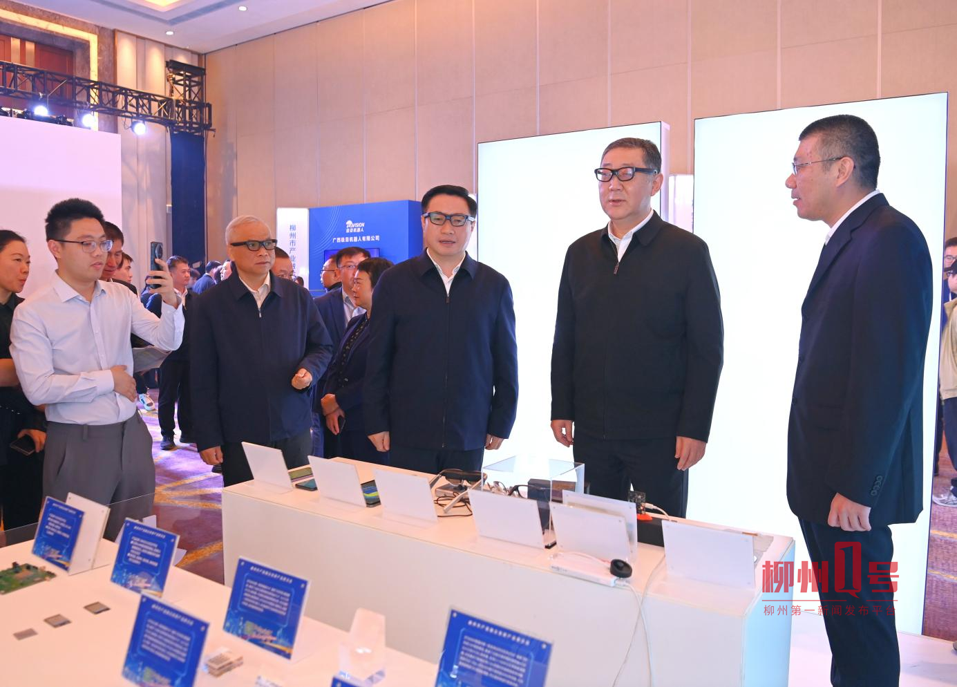 张壮、刘胜友等参观柳州市产业融合发展产品展示会,并试用智能眼镜。